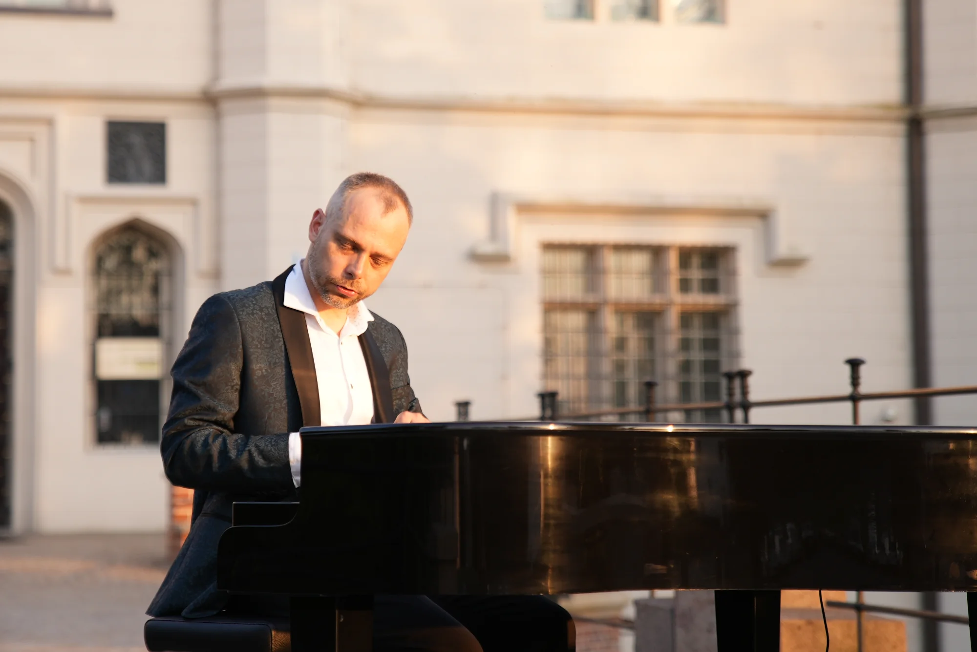 Pianista gra na pianinie w plenerze